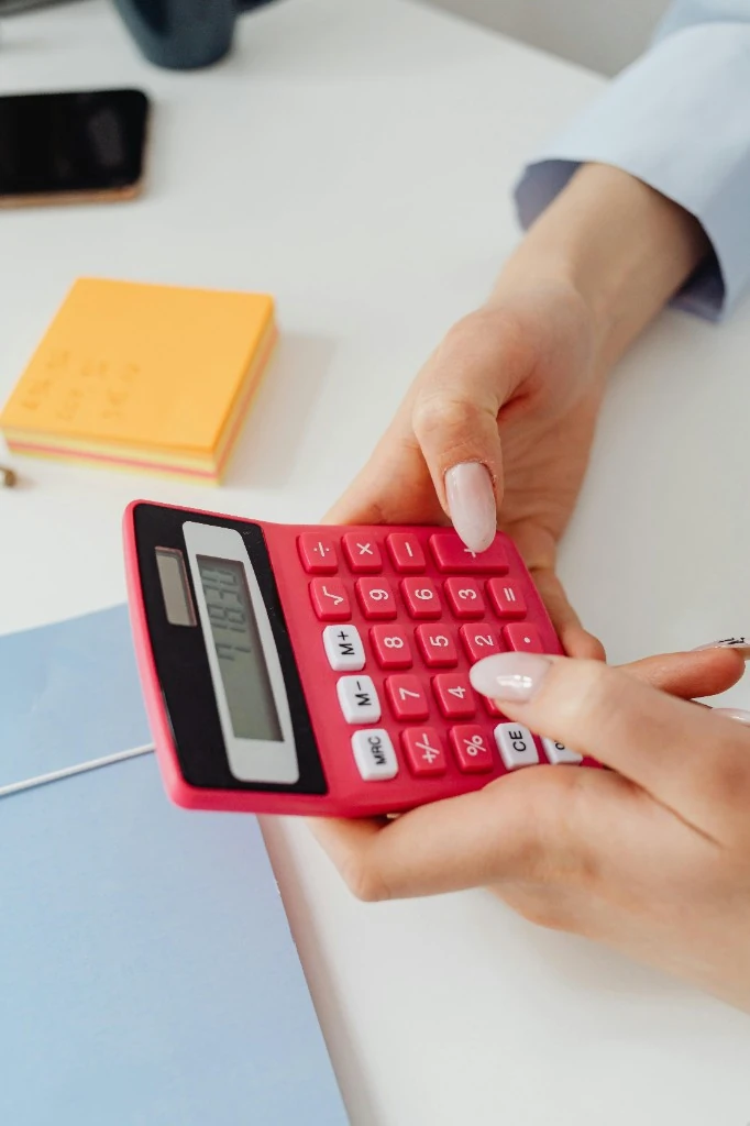 Hand using a calculator on a desk