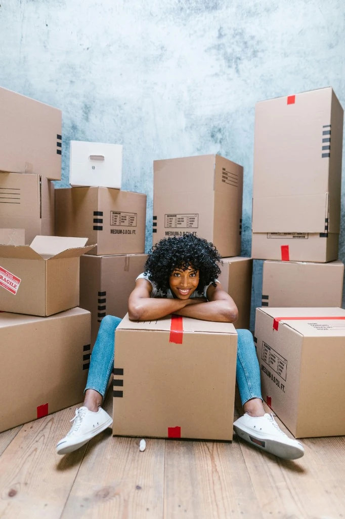 Person sitting confidently among moving boxes
